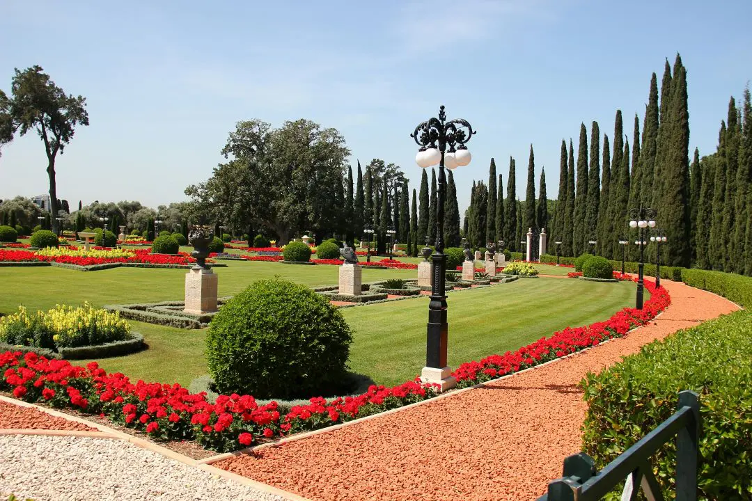 Park mit Blumen, hohen Büschen und Laternen