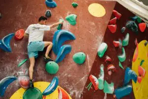 Ein Mann der an einer Kletterwand hochklettert