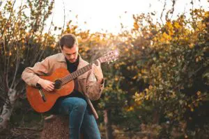 Mann der mit akustischer Gitarre spielt