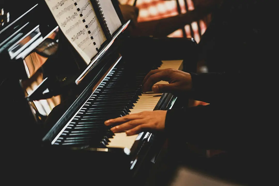 Person die in einem dunklen Raum Klavier spielt