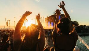 zwei Personen die auf einem Festival ihre Hände in die Luft strecken