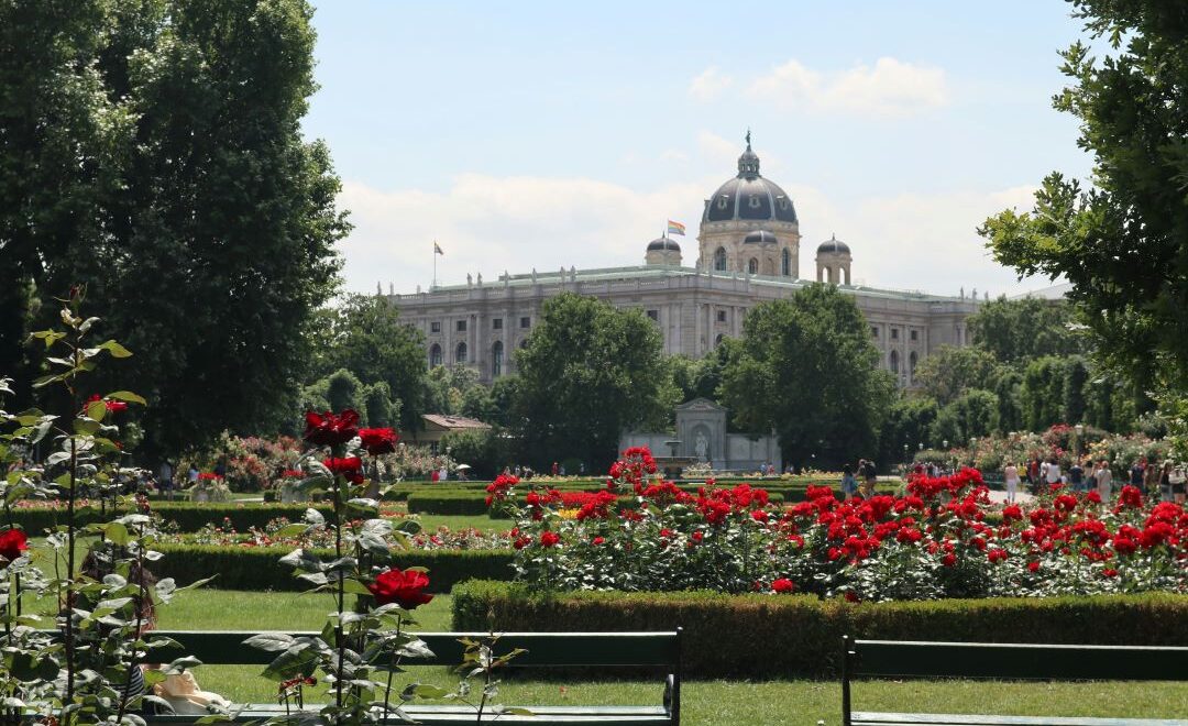 Blick auf Gebäude aus einem Park mit Blumen im Vordergrund