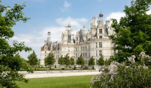 weißes Schloss mit Büschen außen herum