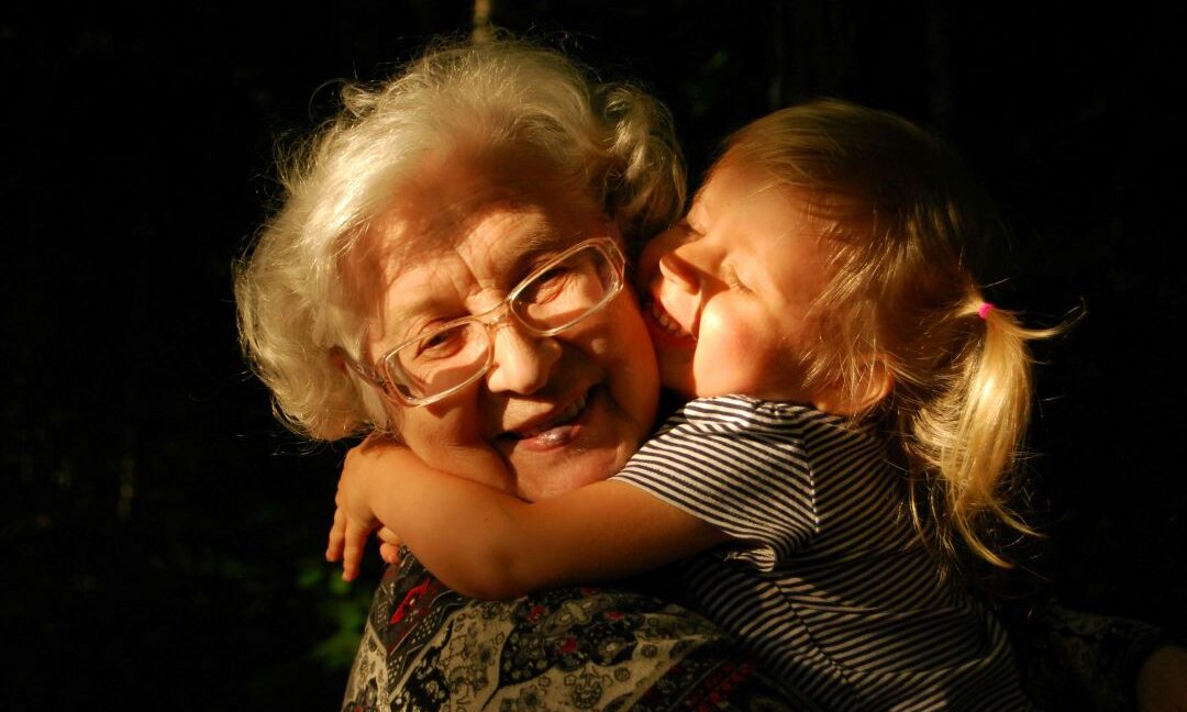 Ältere Dame die ein Kind in ihren Armen hält