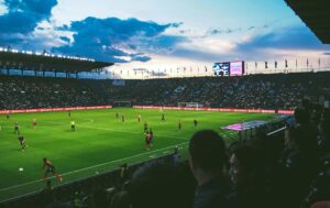 Viele Personen die sich ein Fußballspiel in der Arena anschauen